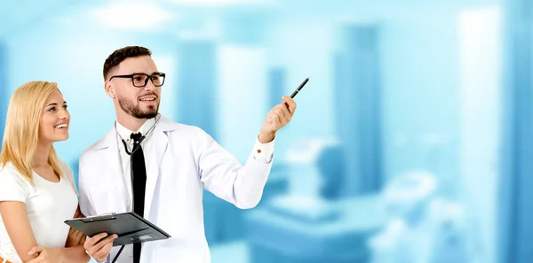 Doctor with patient pointing at empty copy space for your text. The happy patient is listening to explanation from the doctor. Concept of medical healthcare and doctor staff service.