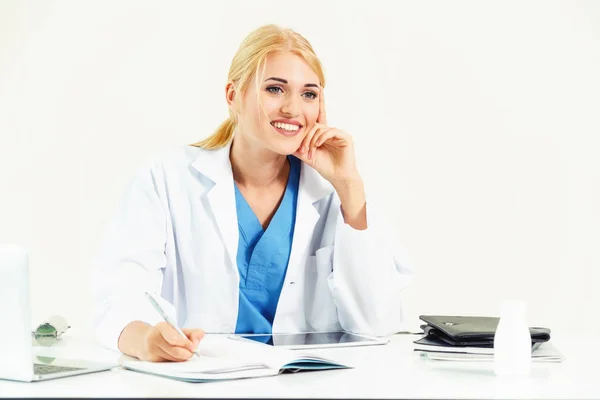 病院やオフィスのテーブルで医療レポートに取り組んでいる医療機関の女性医師 — ストック写真