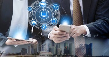 Cep telefonu ile modern şehir binaları arka plan kullanarak genç iş adamları. Gelecekteki telekomünikasyon teknolojisi ve internet şeyler (çok) kavramının.