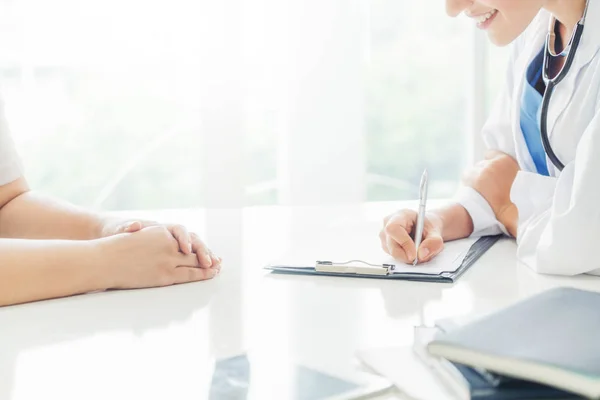 Donna Medico Parla Con Paziente Femminile Mentre Scrive Sulla Cartella — Foto Stock