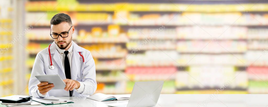 Pharmacist using tablet computer at the pharmacy. Medical healthcare and pharmaceutical staff service.