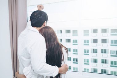 Mutlu genç çift rahatlatıcı sabah uyandıktan sonra eve yatak odasında.