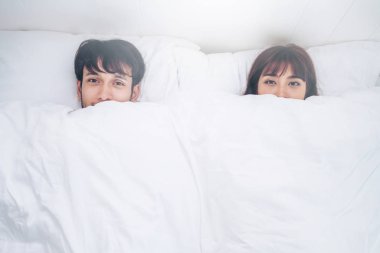 Mutlu genç çift rahatlatıcı sabah uyandıktan sonra eve yatak odasında.