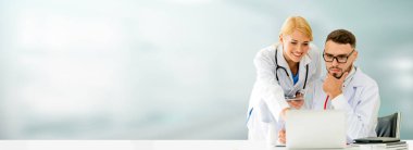 Doktor hastanede başka bir doktor ile bir tartışma yaparken ofiste dizüstü bilgisayarla çalışma. Tıbbi sağlık ve doktor hizmeti.