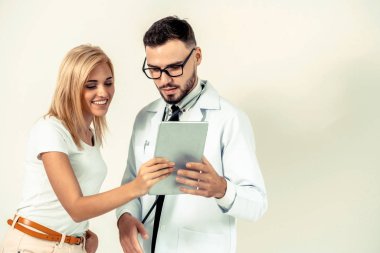 Erkek doktor ve Bayan hasta sağlık veri kaydı için tablet bilgisayar bakıyor. Sağlık ve tıbbi hizmet.