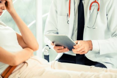 Erkek doktor konuşuyor ve Bayan hasta hastane ofisinde inceleyerek. Sağlık ve tıbbi hizmet.