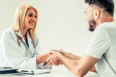 Kadın doktor hastane office odasında erkek hasta ile karşılıklı yapıyor. Sağlık ve Medikal hizmet meslekleri.