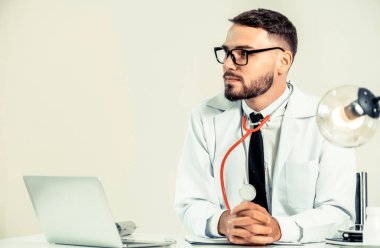 Ofis büro dizüstü bilgisayar üzerinde çalışan hastanede, mutlu erkek doktor. Tıbbi sağlık kavramı.