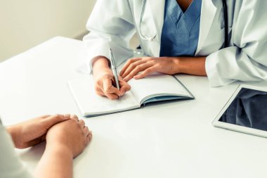 Kadın doktor konuşuyor ve Bayan hasta hastane ofisinde inceleyerek. Sağlık ve tıbbi hizmet.