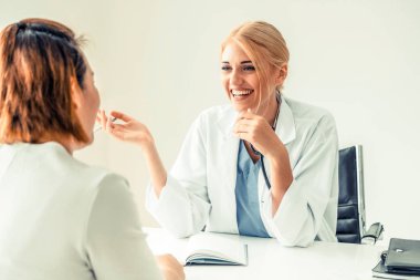 Kadın doktor konuşuyor ve Bayan hasta hastane ofisinde inceleyerek. Sağlık ve tıbbi hizmet.