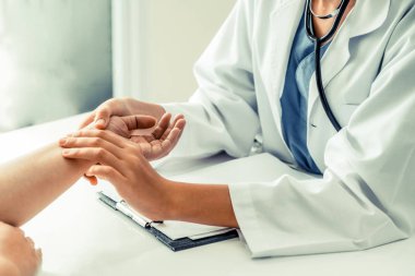 Kadın doktor hastane ofiste bayan hasta için eller tarafından hasta darbe incelenirken konuşuyor. Sağlık ve tıbbi hizmet.