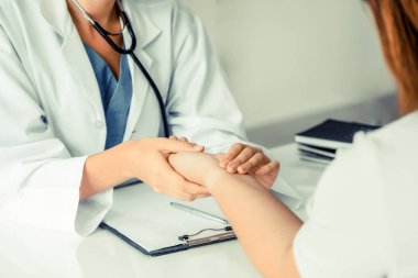 Kadın doktor hastane ofiste bayan hasta için eller tarafından hasta darbe incelenirken konuşuyor. Sağlık ve tıbbi hizmet.