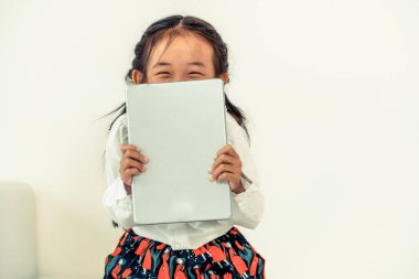 Tablet bilgisayar ile beyaz arka plan üzerinde küçük mutlu çocuk. Çocukluk yaşam tarzı.