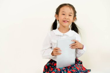 Tablet bilgisayar ile beyaz arka plan üzerinde küçük mutlu çocuk. Çocukluk yaşam tarzı.