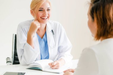 Kadın doktor konuşuyor ve Bayan hasta hastane ofisinde inceleyerek. Sağlık ve tıbbi hizmet.