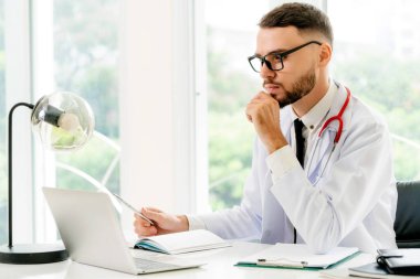 Doktor hastanede Ofis masaları, dizüstü bilgisayar üzerinde çalışıyor. Tıbbi ve sağlık kavramı.