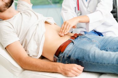 Kadın doktor konuşuyor ve erkek hasta hastane ofisinde inceleyerek. Sağlık ve tıbbi hizmet.