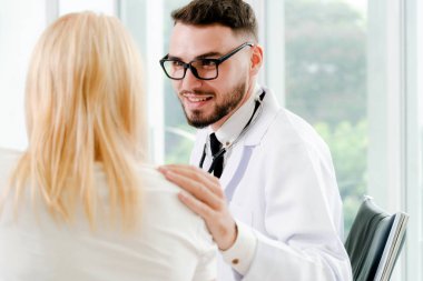 Erkek doktor hastane ofiste bayan hasta ile konuşuyor. Sağlık ve tıbbi hizmet.
