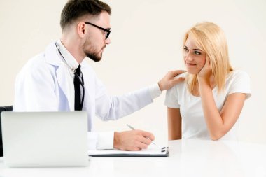 Hastanın sağlık kaydının tablosundaki tarih yazarken hastane ofiste bayan hasta için erkek doktor konuşuyor. Sağlık ve tıbbi hizmet.