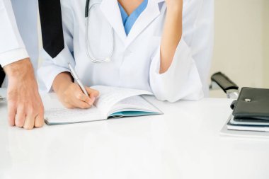 Doktor hastane ofis notlar hastalar raporda başka bir doktor ile konuşma yaparken o ayakta yanında yazıyor.