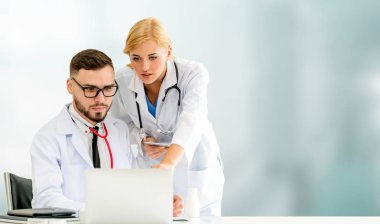 Doktor hastanede başka bir doktor ile bir tartışma yaparken ofiste dizüstü bilgisayarla çalışma. Tıbbi sağlık ve doktor hizmeti.