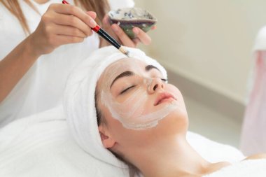 Güzeller güzeli kadın, sağlık merkezindeki profesyonel dermatologdan yüz temizleme tedavisi görüyor. Yaşlanma önleyici, yüz bakımı ve lüks yaşam tarzı konsepti.