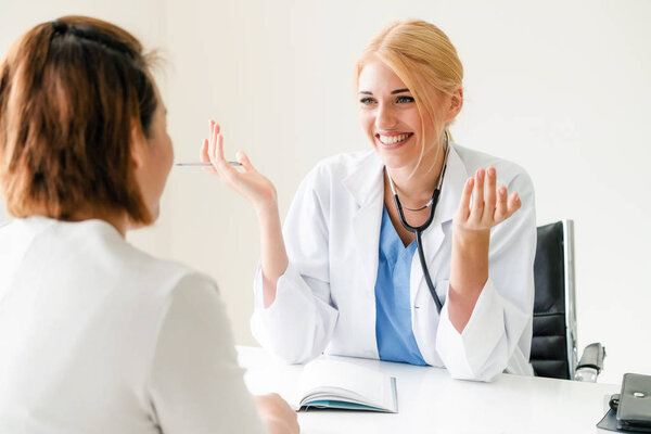 Woman doctor is talking and examining female patient in hospital office. Healthcare and medical service.