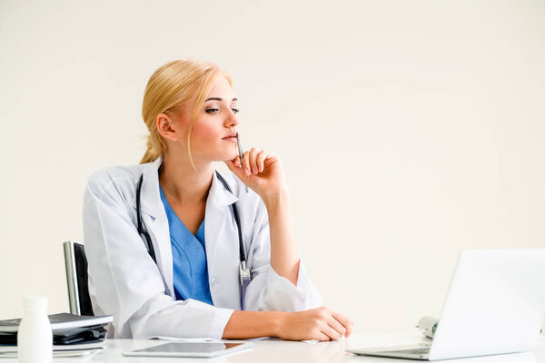 Женщина-врач в больнице или институте здравоохранения работает над медицинским отчетом за рабочим столом
.