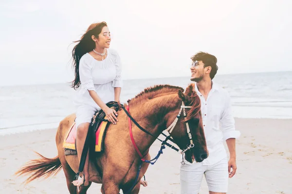 年轻夫妇去蜜月骑马在海滩上的夏天假期 — 图库照片