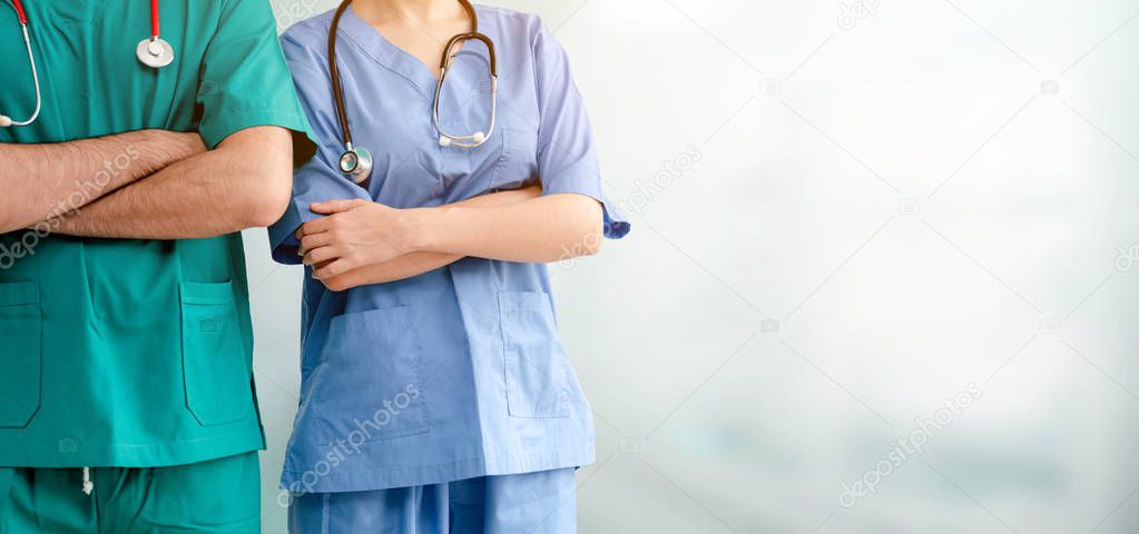 Two hospital staffs - surgeon, doctor or nurse standing with arms crossed in the hospital. Medical healthcare and doctor service.