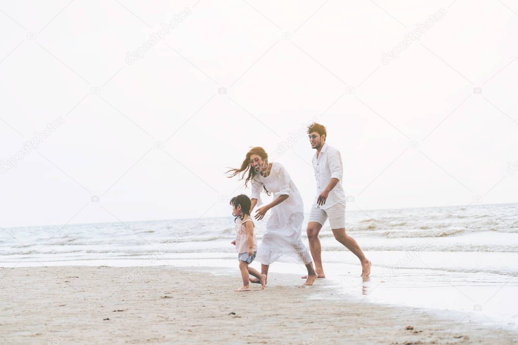 Happy family of father, mother and kids goes vacation on a tropical sand beach in summer.