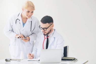 Doktor hastane ofis dizüstü bilgisayar masanın üzerinde başka bir doktor hasta sağlık hakkında tartışma ile çalışma.
