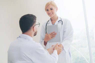 El sıkışma başarı ve profesyonel sağlık personeli ekip çalışması gösteren başka bir doktora veren hastanede doktor.