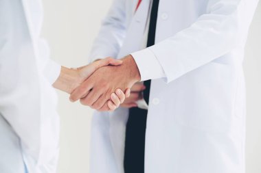 Doktor el sıkışma başarı ve ekip çalışması profesyonel sağlık insan gösteren başka bir doktora veren beyaz arka plan üzerinde. Doktorlar boyuyla yakın çekim.