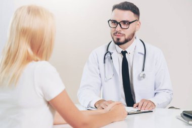 Erkek doktor hastane ofiste bayan hasta konuşuyor. Sağlık ve tıbbi hizmet.