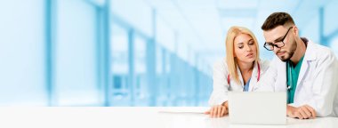 Doktor hastanede başka bir doktor ile bir tartışma yaparken ofiste dizüstü bilgisayarla çalışma. Tıbbi sağlık ve doktor hizmeti.