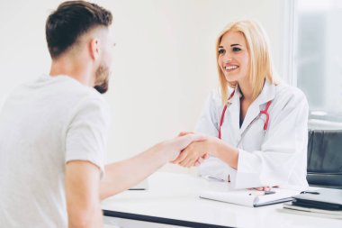 Kadın doktor hastane office odasında erkek hasta ile karşılıklı yapıyor. Sağlık ve Medikal hizmet meslekleri.