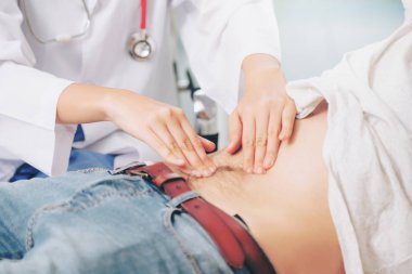 Kadın doktor konuşuyor ve erkek hasta hastane ofisinde inceleyerek. Sağlık ve tıbbi hizmet.