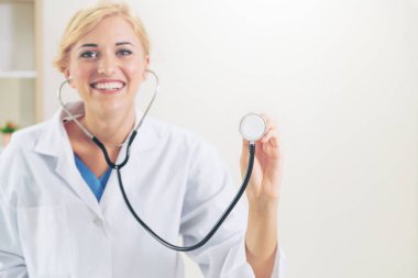 Genç kadın doktor işaretleme stetoskop boş alan. Seçici odak doktorlar el at. Tıbbi sağlık kavramı.