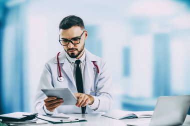 Hastanede tablet bilgisayar kullanan bir doktor. Sağlık ve doktor hizmetleri.