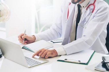 Doktor hastanede Ofis masaları, dizüstü bilgisayar üzerinde çalışıyor. Tıbbi ve sağlık kavramı.