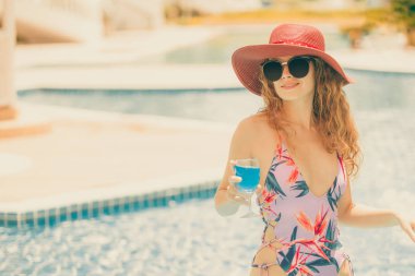 Mutlu genç kadın lüks resort yüzme havuzunda, iyi vakit geçiriyor mayo giyiyor. Yaz seyahat tatil kavramı.