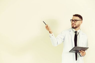 Erkek doktor puan kalem boş kopya alanı başka bir elinde bir belge Pano tutarken.