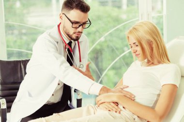 Erkek doktor konuşuyor ve Bayan hasta hastane ofisinde inceleyerek. Sağlık ve tıbbi hizmet.