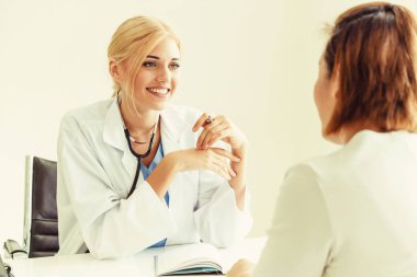 Kadın doktor konuşuyor ve Bayan hasta hastane ofisinde inceleyerek. Sağlık ve tıbbi hizmet.