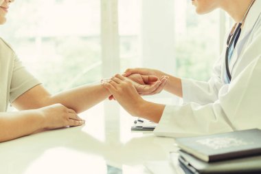 Kadın doktor hastane ofiste bayan hasta için eller tarafından hasta darbe incelenirken konuşuyor. Sağlık ve tıbbi hizmet.