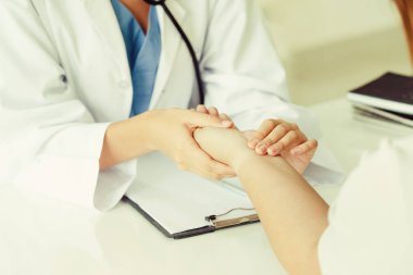 Kadın doktor hastane ofiste bayan hasta için eller tarafından hasta darbe incelenirken konuşuyor. Sağlık ve tıbbi hizmet.