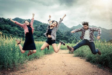 Gençlerin grup dağ ve doğa iz seyahat ederken havada atlama mutlu. Seyahat ve açık hava yaşam tarzı kavramı.