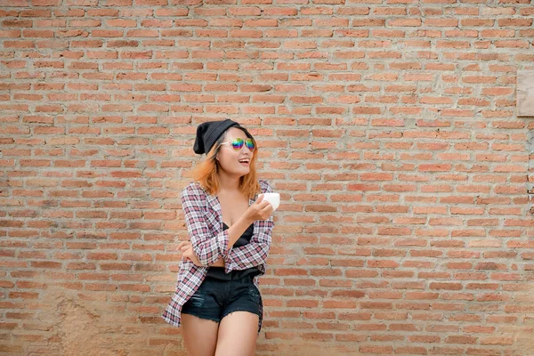 Glückliche Junge Hipsterfrau Die Mit Kaffeetasse Der Hand Einer Mauer — Stockfoto