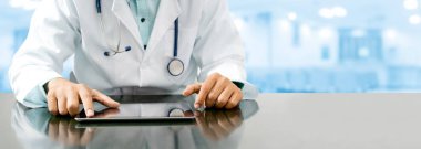 Tablet bilgisayar Hastanesi Office ile masada oturan erkek doktor. Tıbbi sağlık personeli ve doktor hizmeti.
